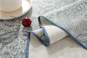 Detail of blue floral waterproof tablecloth with fine texture and stitched edges