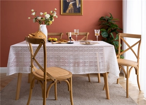 Detailed view of intricate white lace tablecloth with floral hollow patterns
