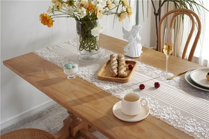Detail of elegant white lace table runner with scalloped edges for wedding decoration
