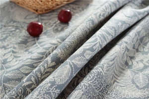 Close-up of gray floral waterproof tablecloth fabric with white leaf and flower patterns