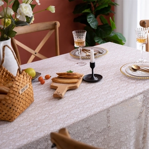 Detail of white French lace tablecloth showing intricate hollow floral crochet patterns