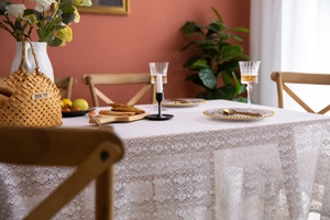 Detail of white French lace tablecloth showing intricate hollow-out floral patterns and texture