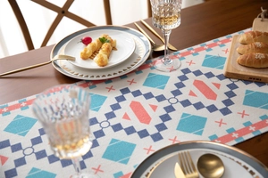 Detail of colorful geometric woven table runner with boho diamond patterns and tassels