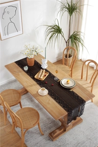Detailed close-up of a black lace table runner with fine vertical stripes and elegant borders