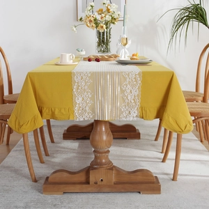 Mustard cotton tablecloth with elegant white lace table runner in a cozy dining room