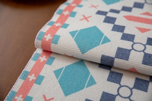 Macro shot of geometric woven table runner showing thick fabric texture and tassel fringe