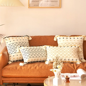 Dettaglio della fodera per cuscino boho con tufting geometrico e nappe agli angoli