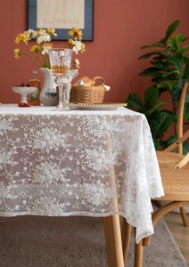 Vue détaillée des motifs floraux en dentelle blanche et des bords festonnés du tapis