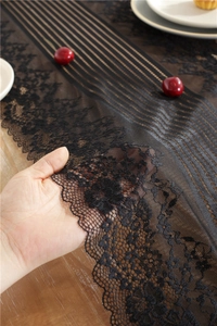 Detailed view of black floral lace table runner with soft semi-transparent mesh texture