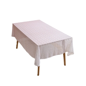 White French lace tablecloth with geometric hollow patterns on a wooden dining table