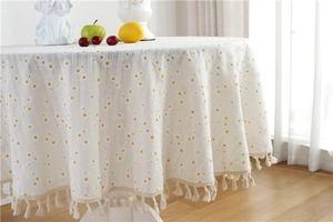 Close-up of yellow daisy floral cotton jacquard tablecloth with beige tassel fringe edge
