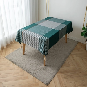 Close-up of geometric green and white plaid tablecloth with decorative fringe tassels