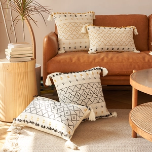 Dettaglio delle federe per cuscini bohémien con motivi geometrici e nappe decorative