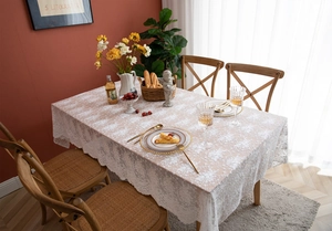 Détail de la nappe en dentelle blanche française avec broderie florale sur bois
