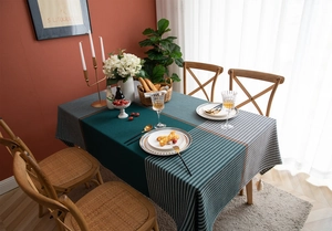 Detail of checkered houndstooth tablecloth with green color block and tassel edge