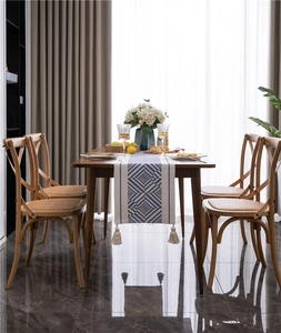 Blue and white geometric table runner with tassels on a dark wood dining table