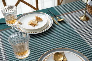 Detailed texture of green striped jacquard tablecloth with geometric patterns and fringe
