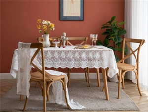 Détail de nappe en dentelle blanche avec broderie florale et bords festonnés