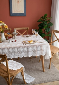 Détail de nappe en dentelle blanche française avec broderie florale 3D et bords festonnés
