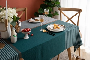 Macro detail of dark teal and houndstooth tablecloth fabric with white tassel fringe