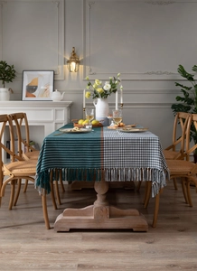 Detail of green stripes and houndstooth pattern tablecloth with elegant fringe tassels