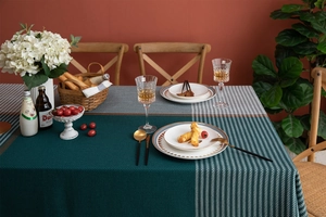 Detail of emerald green and grey houndstooth tablecloth with woven texture and gold thread