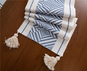 Close-up of geometric pattern and cotton tassels on a bohemian style woven table runner
