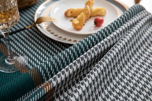 Close-up of green houndstooth jacquard tablecloth with orange stripe and woven texture