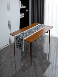 Close-up of modern black and white jacquard table runner with letter print on wood table