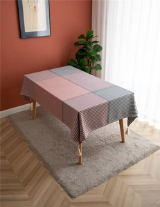 Close-up of pink and grey checkered tablecloth with tassels and houndstooth pattern