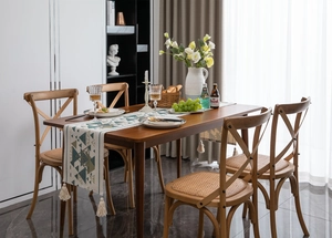 Dettaglio del runner da tavolo geometrico con triangoli verdi e nappe su legno