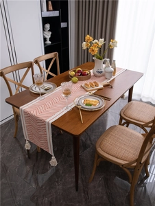Detailed view of bohemian table runner with orange waves and white tassel edges
