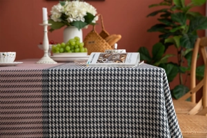 Detail of houndstooth patchwork tablecloth with pink and grey patterns and large tassels