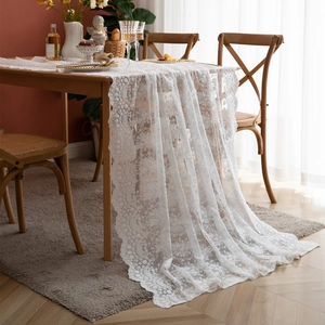 Détails de la dentelle blanche avec motifs floraux et bords festonnés sur nappe rectangulaire