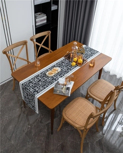 Close-up of black and white jacquard table runner with modern letter print on wooden table