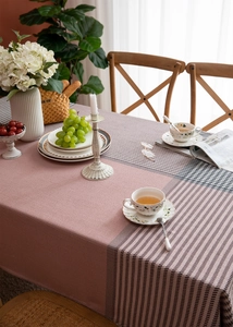 Detail of dusty rose and black houndstooth jacquard tablecloth with large fringes and textures