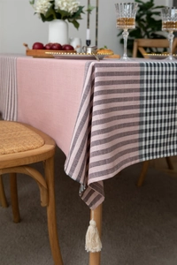 Close-up of pink jacquard tablecloth featuring tassels and striped geometric pattern
