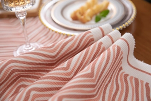 Close-up of woven wave pattern table runner with fringed edges and warm texture