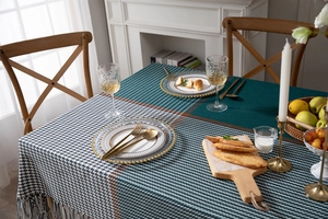 Detail of thickened green houndsstooth tablecloth with grey tassels and geometric patterns