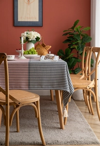 Detail of classic houndstooth tablecloth with white fringe tassels on a dining table