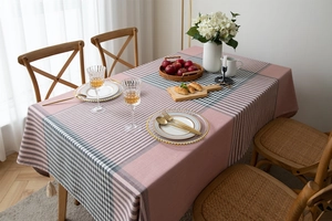 Detail of modern pink and grey geometric plaid tablecloth with decorative fringe tassels