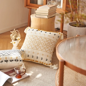 Fodere per cuscini boho in cotone lavorato a maglia con nappe e motivi su divano in legno