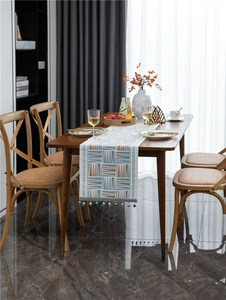 Close-up of geometric chenille table runner featuring orange and blue triangular patterns