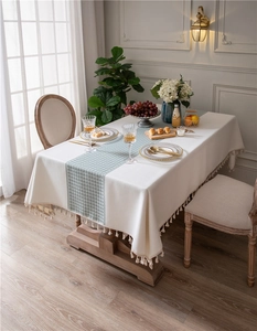 Detail of green houndstooth tablecloth with tassel fringe in French country style decor