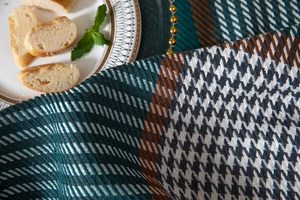 Close-up of thick houndstooth jacquard fabric with fringed edges and geometric weave