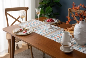 Detail of colorful geometric boho table runner with cotton tassels and fabric texture