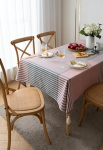 Detailed view of pink and grey checkered tablecloth with decorative white tassels