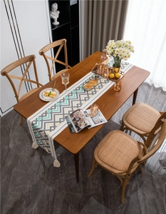 Dettaglio del runner da tavola intrecciato con motivo chevron e nappe in cotone
