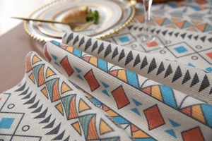 Close-up of bohemian table runner with thick woven texture and geometric tassel pattern
