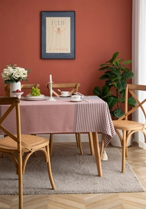 Close-up of pink linen-blend tablecloth featuring striped edge and white tassel detail